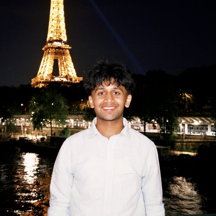 Abhi in front of the Eiffel Tower lit up at night