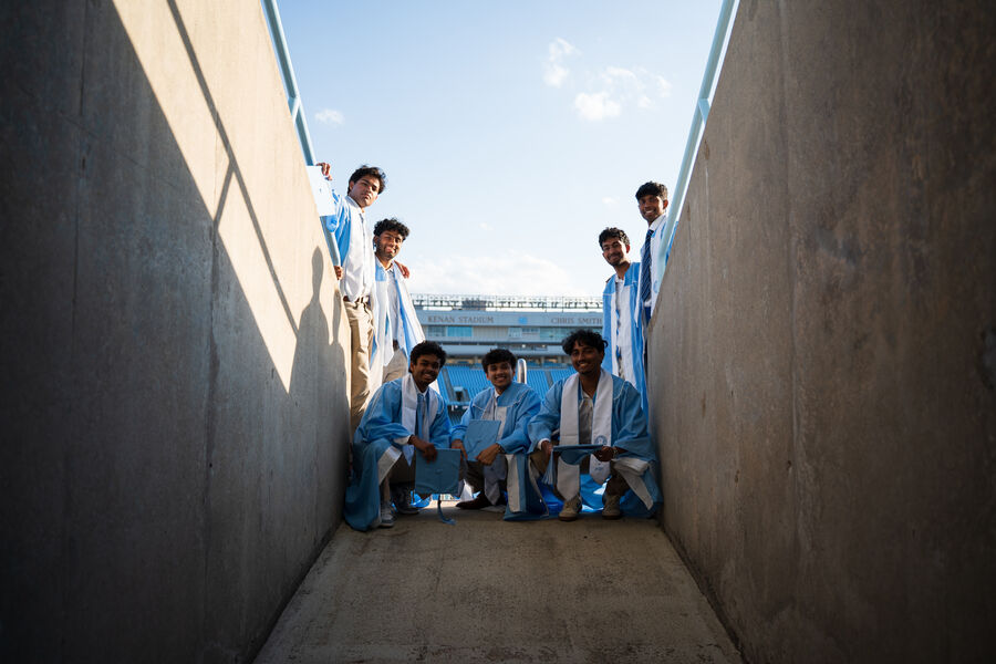 Graduates gathered in a stadium tunnel, photographed from below