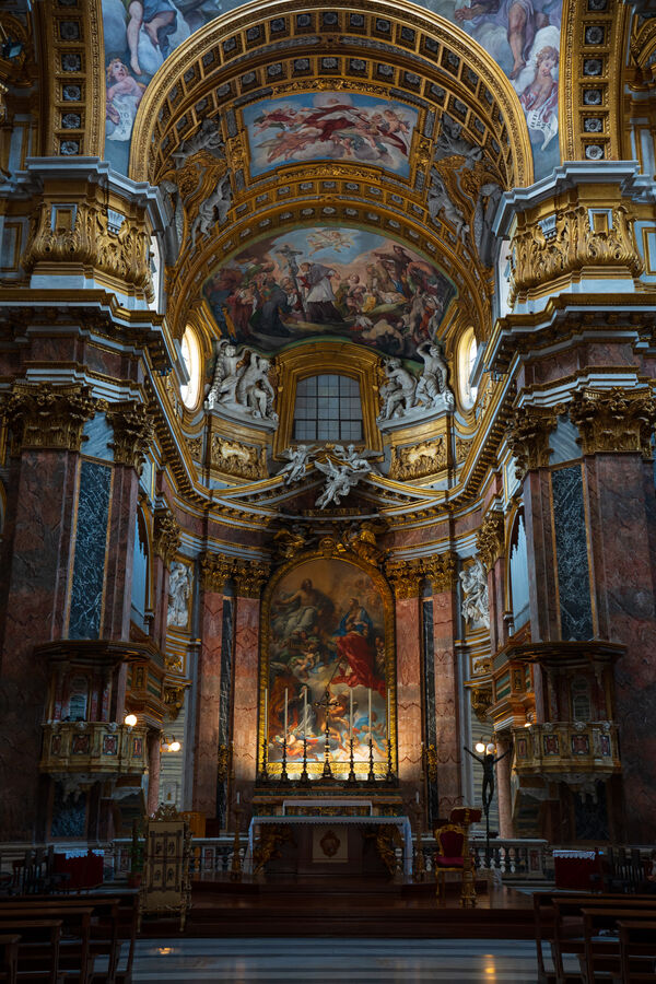 The painted interior of a baroque church, looking toward the altar